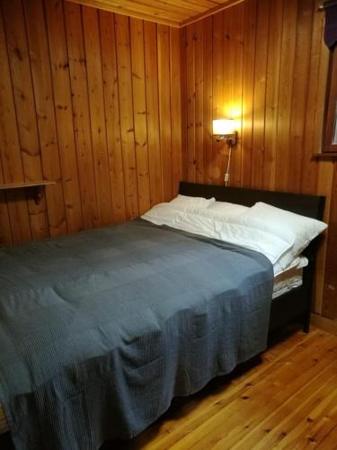 a bedroom with a bed in a wooden wall at Lakeland Karelia Fisherman's Paradise in Kesälahti