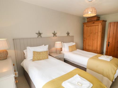 two beds in a small room with two lamps at Hutchinson House in Richmond