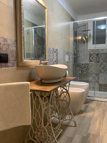 een badkamer met een wastafel, een toilet en een spiegel bij B&B villa Gallo in Torre Squillace