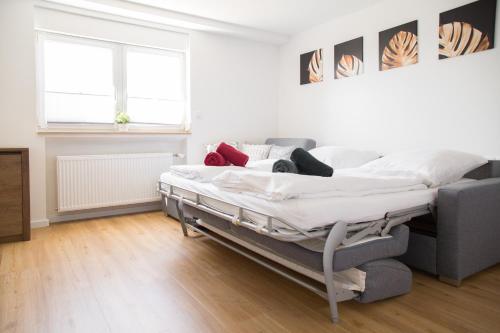 a white bedroom with a bed and a couch at Ferienwohnung Am Kahlenberg - Ringsheim in Ringsheim