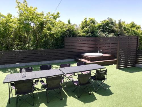 a patio with a table and chairs and a sink at 海まで3分の貸別荘 Malibu Ichinomiya バレルサウナ ジャグジー BBQ完備 in Ichinomiya