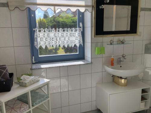un bagno con lavandino e finestra di Haus Rose a Ribnitz-Damgarten