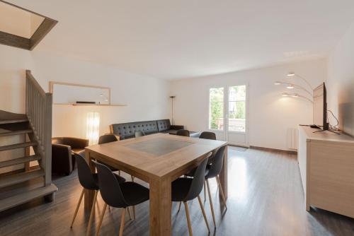 une salle à manger avec une table et des chaises en bois dans l'établissement Cosy house near Disneyland BMYGUEST, à Bailly-Romainvilliers