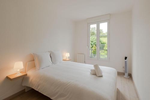 Un dormitorio blanco con una cama blanca y una ventana en Cosy house near Disneyland BMYGUEST, en Bailly-Romainvilliers