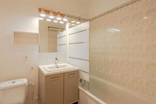une salle de bain avec un lavabo, des toilettes et un miroir dans l'établissement Cosy house near Disneyland BMYGUEST, à Bailly-Romainvilliers