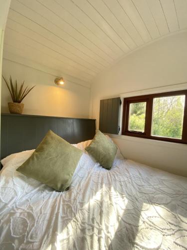 a bedroom with a bed with two pillows on it at Heywood Glamping in Ormskirk