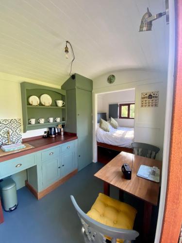 a bedroom with a bed and a desk and a table at Heywood Glamping in Ormskirk