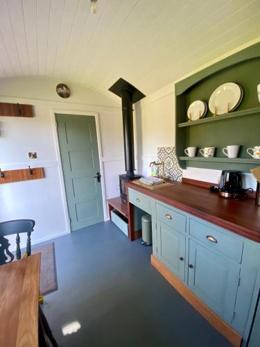 a kitchen with blue cabinets and a stove at Heywood Glamping in Ormskirk