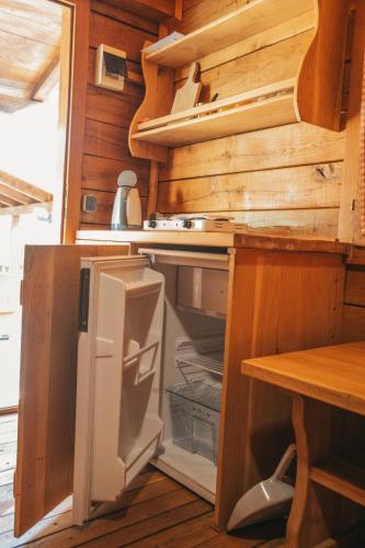 a kitchen with an open refrigerator and a table at River huts Zrmanja in Obrovac