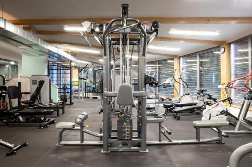 a gym with several treadmills and exercise bikes at Amenity Hotel & Resort Lipno in Lipno nad Vltavou