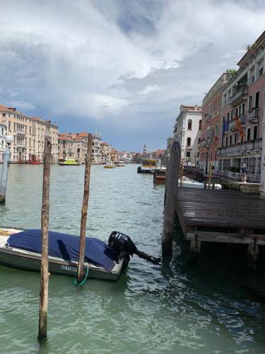 a boat tied to a dock in a canal at Familly rooms (two rooms) Cà del Traghetto in Venice