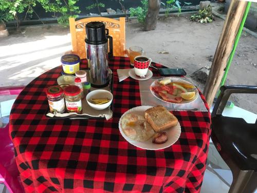a picnic table with a plate of food on a checkered table cloth at L&J Modern Backpackers Kinondoni in Dar es Salaam