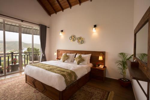 a bedroom with a large bed and a large window at C I Residence in Nuwara Eliya