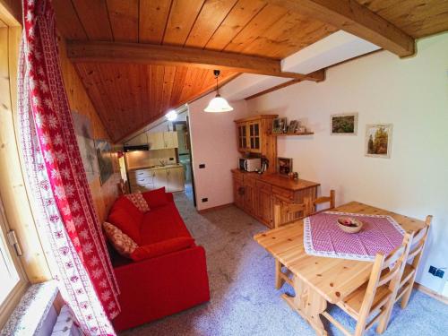a living room with a red couch and a table at La Piana Appartamenti in Alpe Devero