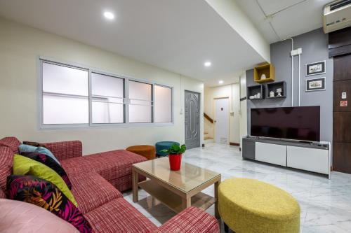 a living room with a couch and a tv at At FOUR-6 Bed, CITY CENTER, Nana BTS, MBK, Central World, Siam in Bangkok