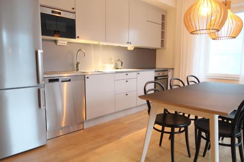 eine Küche mit einem Tisch und einem Kühlschrank in der Unterkunft Luxury Business Apartments 2 rooms #2 1-4 people in Sundbyberg