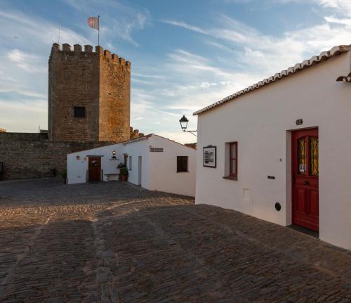 um grupo de edifícios brancos com uma torre em A Janela Do Castelo em Monsaraz