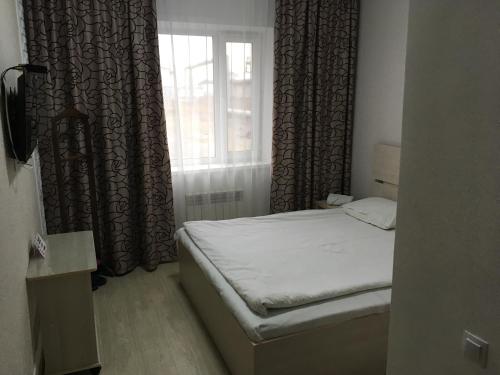 una piccola camera con letto e finestra di Гостиница"Hostel" a Karagandy
