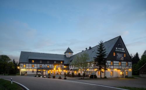 ein großes Schwarz-Weiß-Gebäude mit Beleuchtung in der Unterkunft Landhotel Altes Zollhaus in Hermsdorf