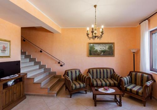 un soggiorno con due sedie e una scala di Casa De Sanctis - Irpinia a Morra De Sanctis