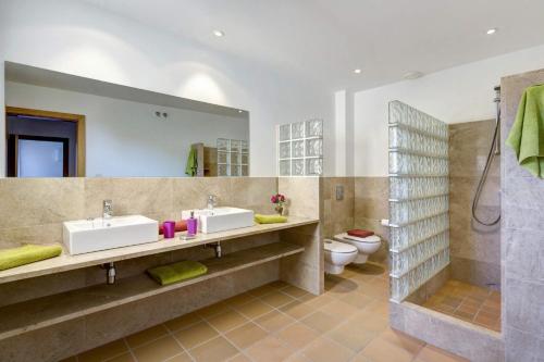Un baño con dos lavabos y una ducha. en Villa Julietta by Villa Plus, en Cala Galdana