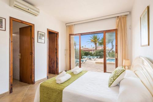 a bedroom with a bed and a view of a pool at Villa Es Pins by Villa Plus in Son Carrio