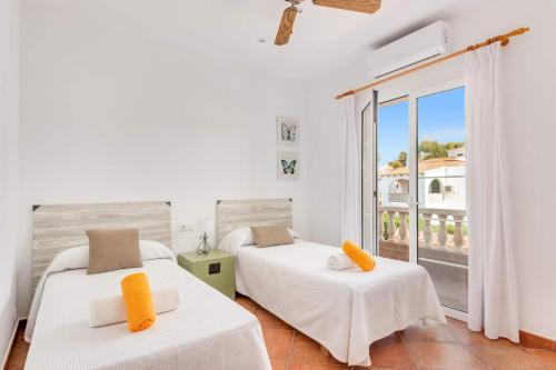 a bedroom with two beds and a balcony at Villa Maria Isabel in Cala Blanca