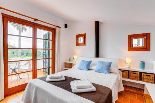 a bedroom with a large bed with blue pillows on it at Villa Can Idu by Villa Plus in El Port