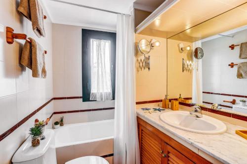 a bathroom with a sink and a tub and a toilet at Villa Can Idu by Villa Plus in El Port