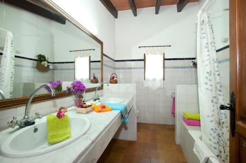 een badkamer met een wastafel, een bad en een spiegel bij Villa Miguel by Villa Plus in El Port