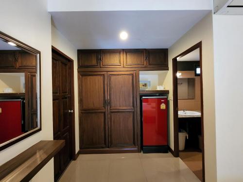 una cucina con frigorifero rosso e armadietti in legno di La-or Resort a Hua Hin