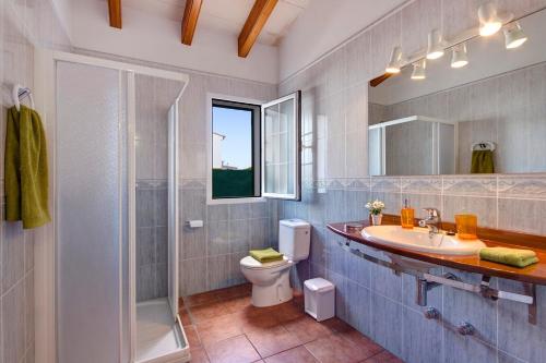 a bathroom with a toilet and a sink and a shower at Villa Saona by Villa Plus in Es Mercadal