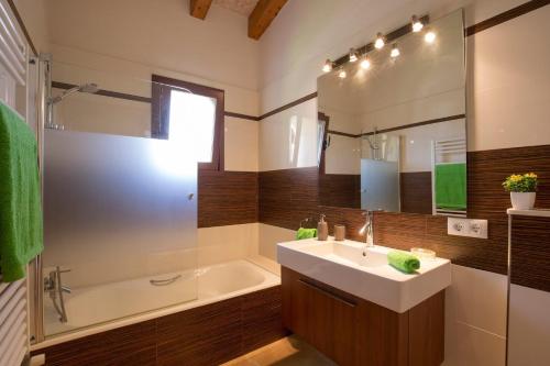 W łazience znajduje się umywalka, wanna i lustro. w obiekcie Villa Les Pells by Villa Plus w mieście Crestatx