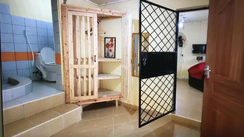 a bathroom with a toilet in a room with a door at Lovely 4-Bed Villa Family oriented or a smallgroup in Diani Beach