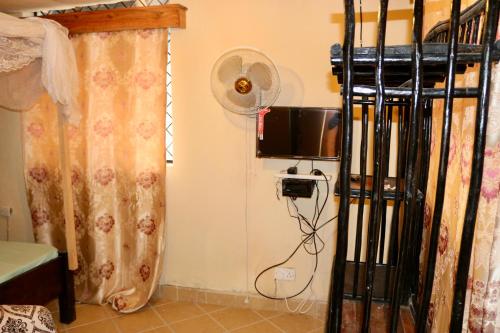 a bedroom with a fan next to a bed at Lovely 4-Bed Villa Family oriented or a smallgroup in Diani Beach