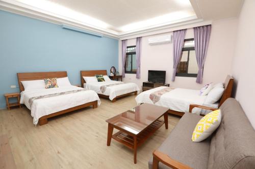 een woonkamer met 2 bedden en een bank bij 小葉園民宿Little Ya B&B in Ruilong