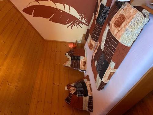 a bed with a quilt hanging on a wall at Mentebauer Traudi's Ferienhof in Rothenthurn
