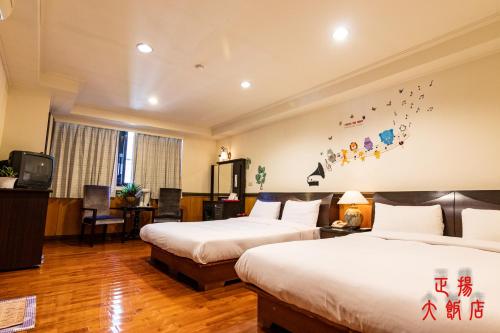 a hotel room with two beds and a tv at Jenq Yang Hotspring Hotel in Renai