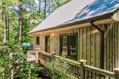 a cabin in the woods with a wooden deck at Osprey Landing in Clarkesville