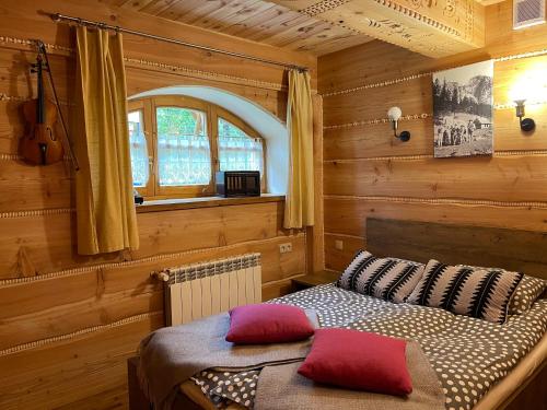 1 dormitorio con 1 cama en una habitación de madera en Siklawa, en Zakopane