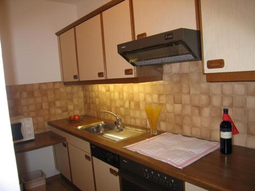 eine Küchentheke mit Spüle und eine Flasche Wein in der Unterkunft Jakob, Landhaus in Tux