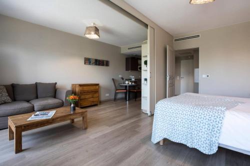 sypialnia z łóżkiem, kanapą i stołem w obiekcie Résidence Bleu Castillet w Perpignanie