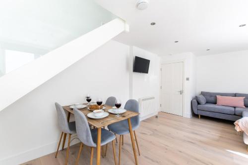 a dining room with a table and chairs and a couch at Beached Az in St Ives