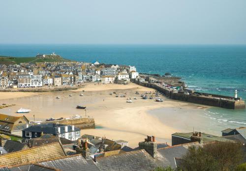 uma vista para uma praia com casas e o oceano em Harbour Vista em St. Ives