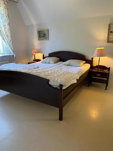 a large bed in a bedroom with two night stands at Trunna Vandrarhem & Konferens in Orsa