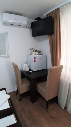 a dining room table with chairs and a microwave at Apartments & Dream Rooms in Niš
