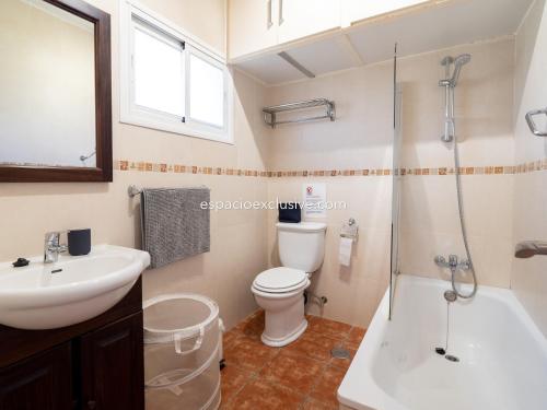 La salle de bains est pourvue de toilettes, d'un lavabo et d'une douche. dans l'établissement MD001 Precioso Apartamento en Primera Linea de Playa, à Mijas