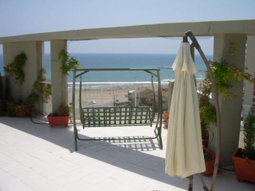 una sombrilla cerrada en un balcón con playa en MAGNIFICO ATICO-DUPLEX FRENTE AL MAR, en El Puig