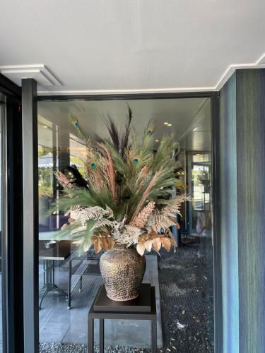 a vase with a plant sitting on a table at Hotel De Bonte Wever Assen in Assen