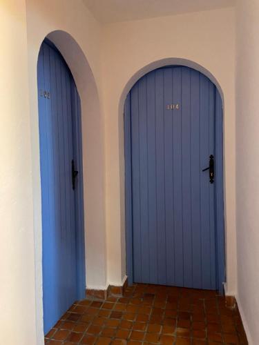 two blue doors in a room with a tile floor at Hotel Alkhalifa in Chefchaouene